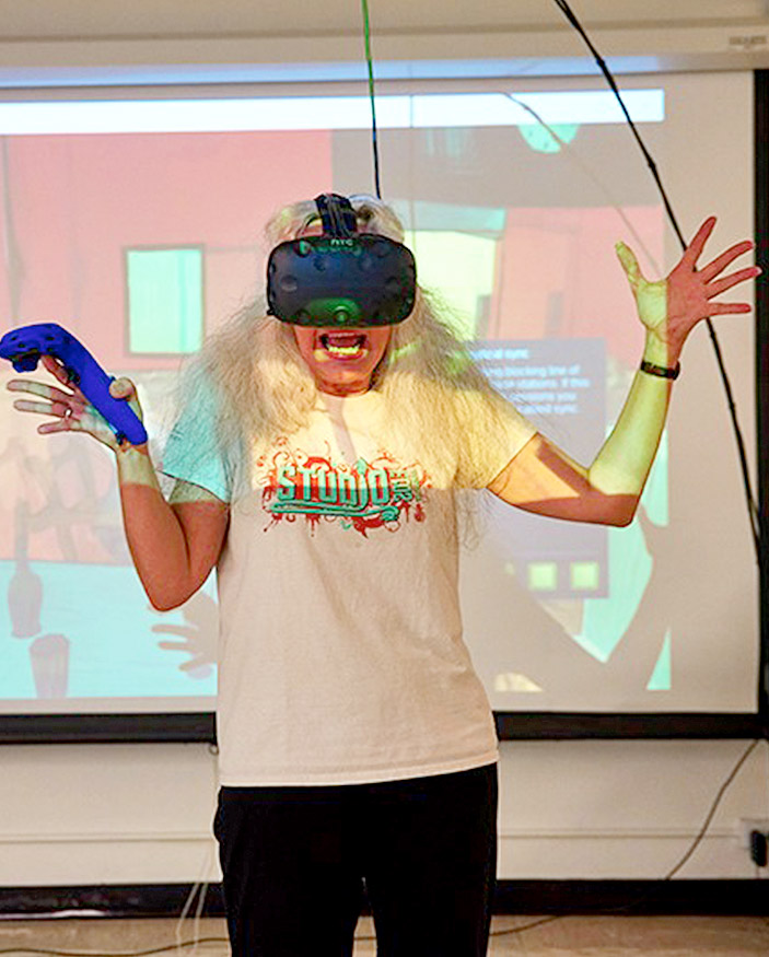 woman wearing vr mask and holding controller in front of a projection screen