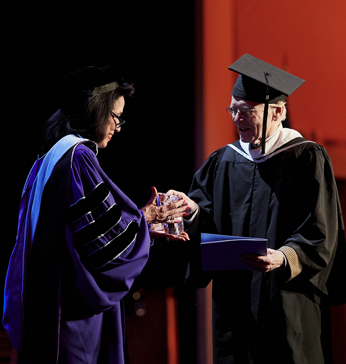 Dr. Joyce F. Brown giving an honorary diploma to a man at FIT commencement