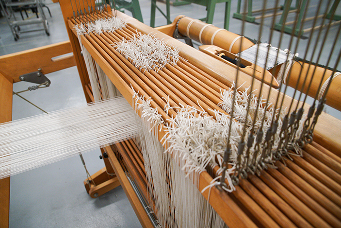 loom machine with yarn being fed through apparatus