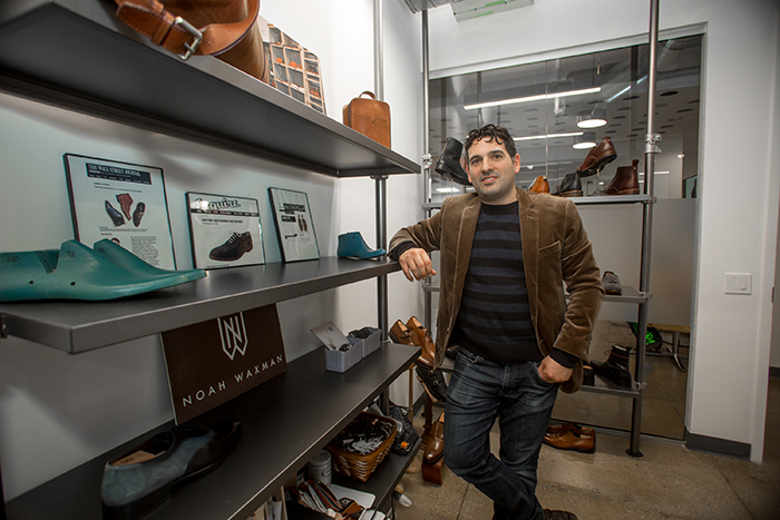 man leaning on shelving unit with shoe forms