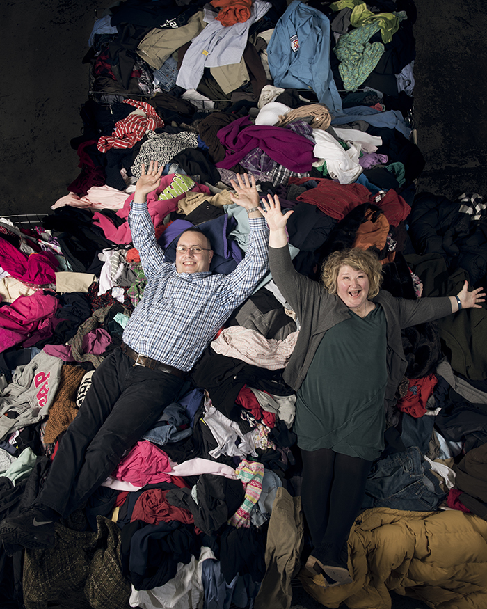 man and woman laying on pile of clothing