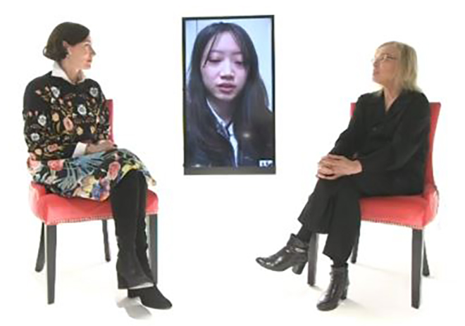 two FIT professors at the virtual fashion show with student on screen